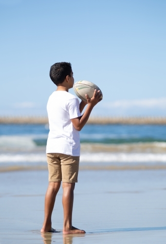 Boy playing with ball on beach
