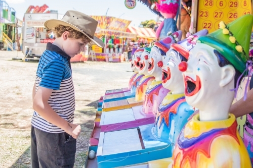 Boy wearing akubra hat playing clown sideshow alley at local show
