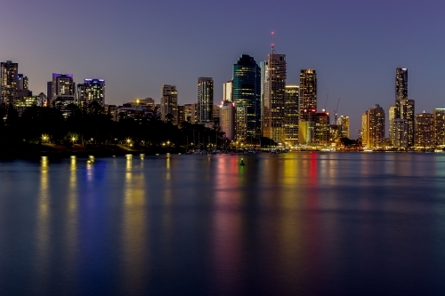 Brisbane CBD skyscrapers beside river with lights reflected