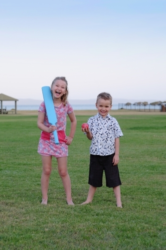 Brother and sister playing cricket in the park