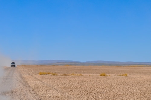 Car traveling on a dry gravel road