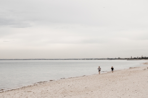 Children running along a beach in Melbourne