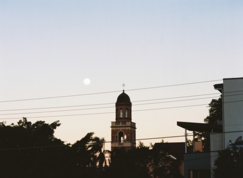 Church Steeple and city Silhouette under a Full Moon At Dusk