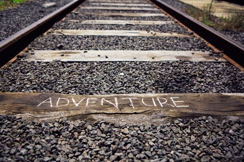 Close up of train track with the word Adventure written on a sleeper