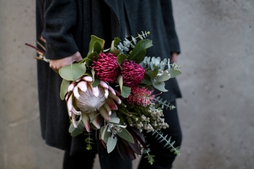 Close up of woman's hand holding a bouquet of native flowers