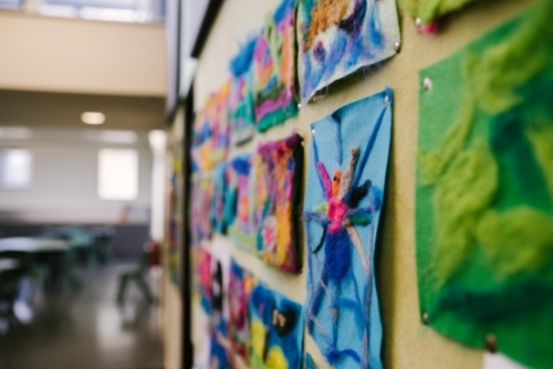 Colourful student artwork on pinboard