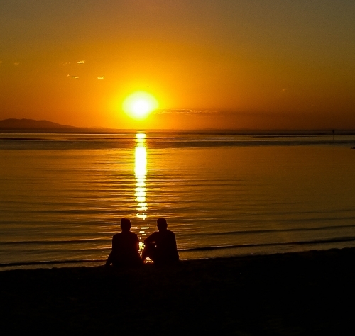 Couple watching the sunset over the water