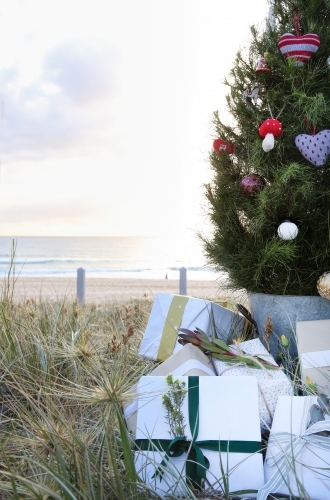 Decorated Christmas tree with presents and beach in background