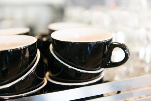 Detail of black coffee cups and glasses stacked in a cafe