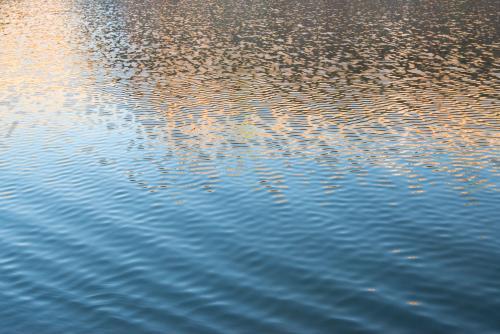 Detail shot of water with ripples and blue and orange tones