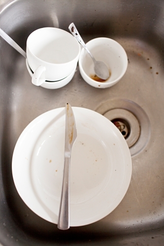 Dirty breakfast dishes sitting in the sink for washing up
