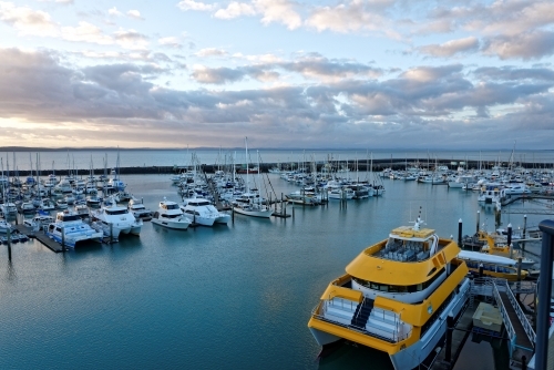 Dramatic clouds at dawn catching the light on the water Hervey Bay marina