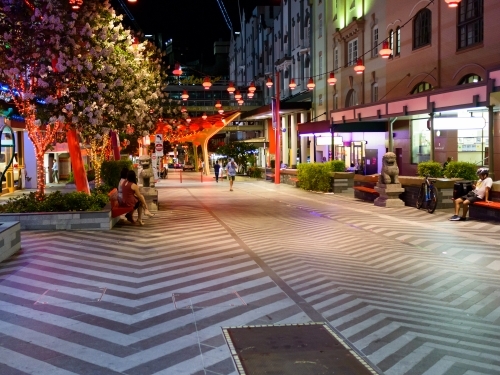 Early evening photo of Chinatown with patterned paving and red lanterns