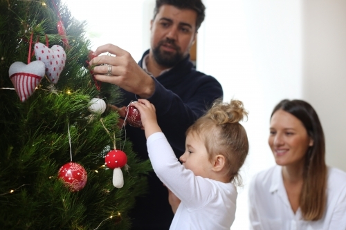Family decorating Christmas Tree