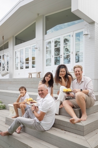 Family eating snacks on backyard stairs