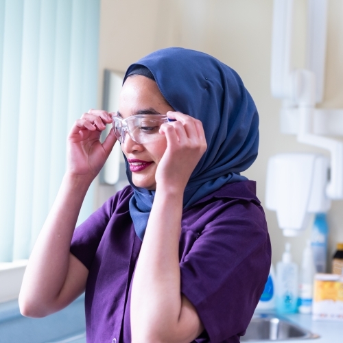 Female dentist wearing hijab with safety glasses