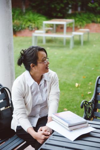 Female university teacher having a discussion at a bench in the garden