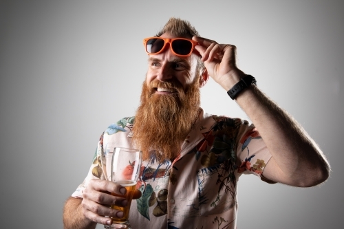 Funky man posing for photographs, holding a glass of beer