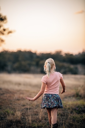 Girl facing into the landscape as she walks away