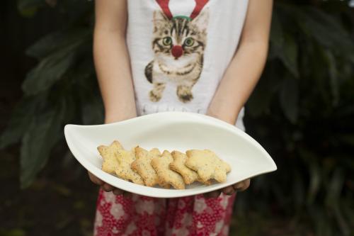 Girl holding a plate of Christmas biscuits