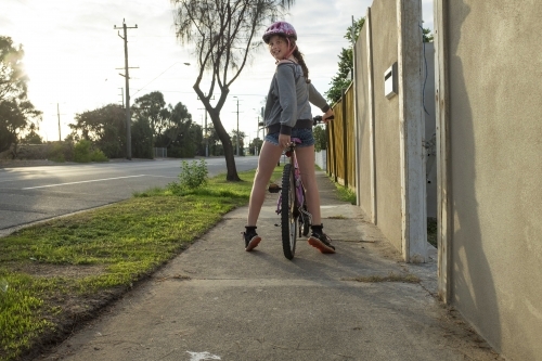 Girl riding bike along urban street