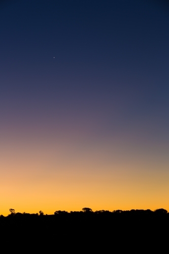 Graduated colour on twilight night sky, with silhouette skyline