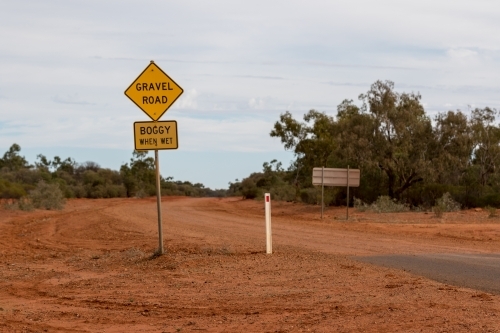 Gravel Road sign on red dirt road