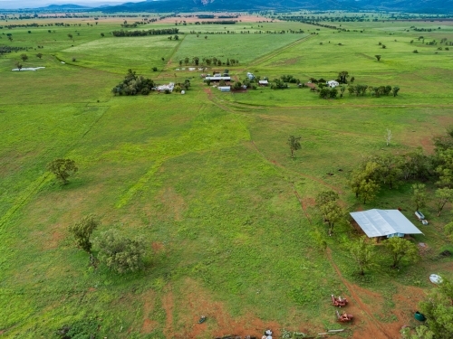 Hay shed on farm with distant homestead buildings and paddocks