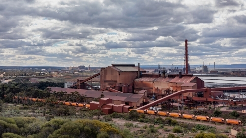 Industrial landscape of steelworks pelletising plant & train delivering iron ore from the mine
