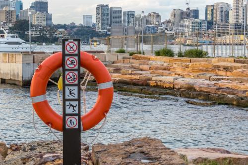 Lifebuoy at city harbour with buildings in distance