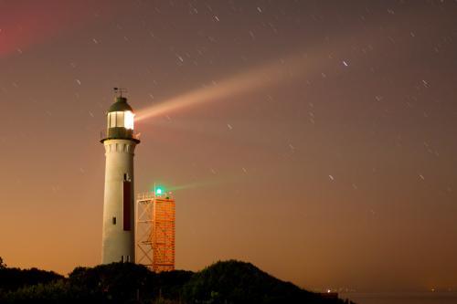 Light beams from a lighthouse at night