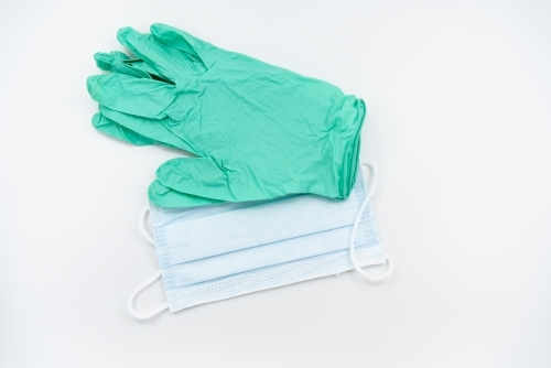 Light green gloves and surgical mask flatlay