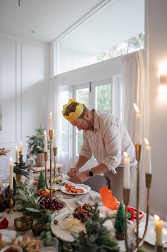Man deveining prawns at Christmas-decorated table
