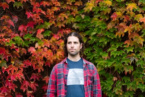 Man in front of changing autumn leaves