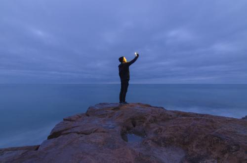 Man Taking Ocean Selfie on Rocks