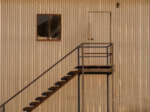 Metal steps on the side of a large corrugated building