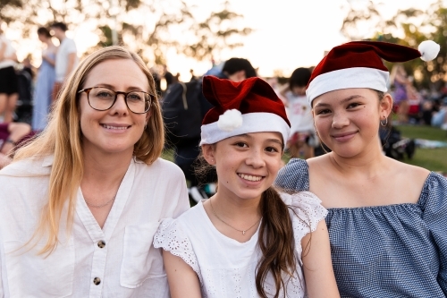 mother and her teenage daughters at a Christmas community event