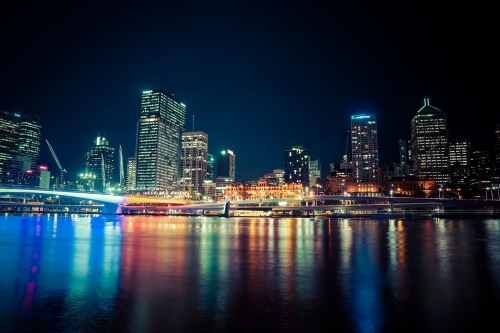 Night view of Brisbane high rise buildings and coloured lights in water