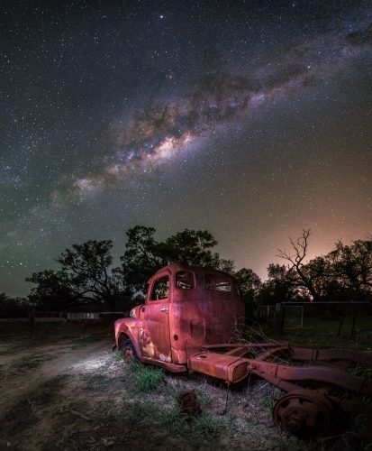 Old abandoned truck in the middle of a field at night