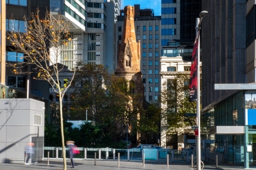 Old sandstone church (St Georges Presbyterian) surrounded by modern buildings