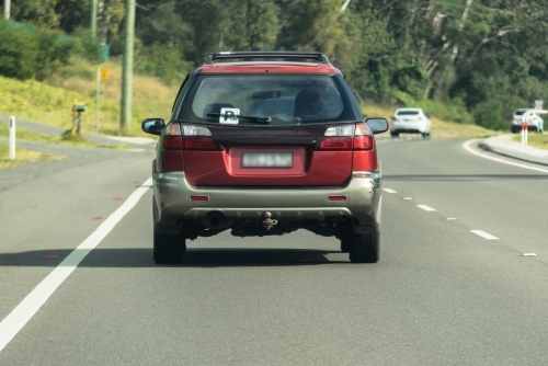 P Plater driving on sealed road in suburban area