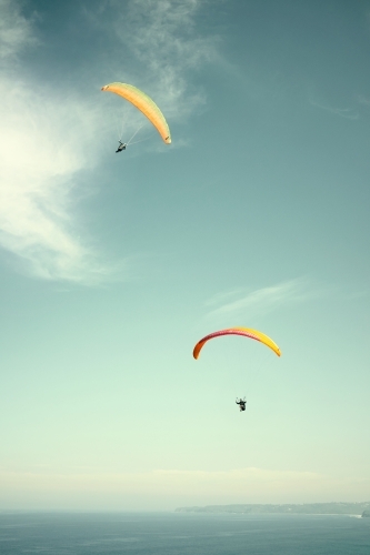 Pair of parachutes / parasailers on a clear day
