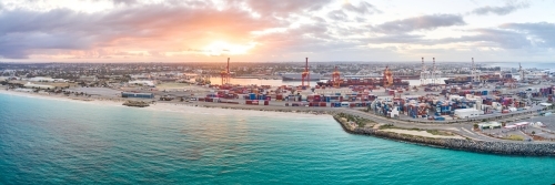 Panorama of the sun rising through clouds over Fremantle Port.