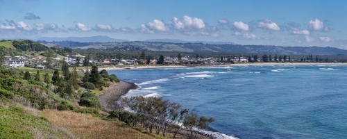Panoramic view of coastal town along coastline, with sandy beach