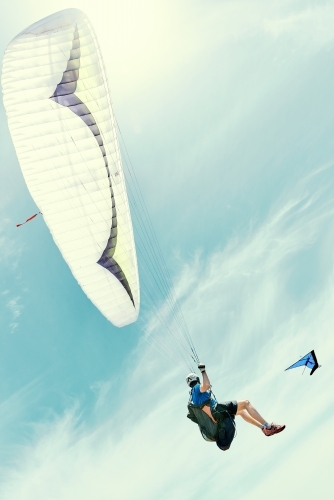 Para sailing with hang glider in the background on a sunny day