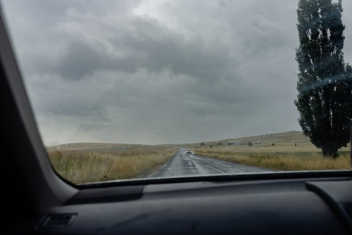 Passenger POV through windscreen / windshield of oncoming ute driving on Australian rural, dirt road
