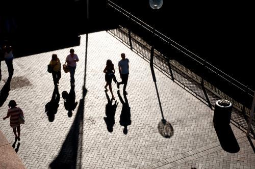 Pedestrians with long shadows at Circular Quay