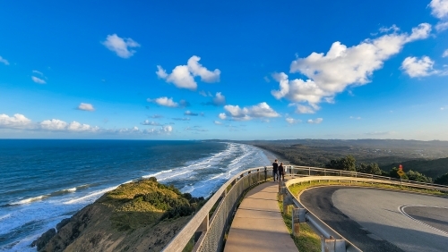 People walking along path at Cape Byron with view over Tallow Beach at Byron Bay