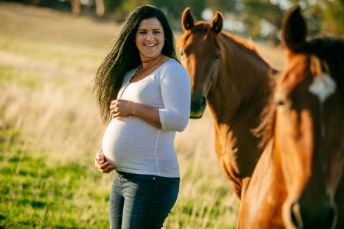 Pregnant woman with her pet horses