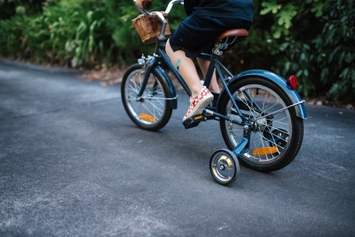 Primary aged girl rides bike on a driveway